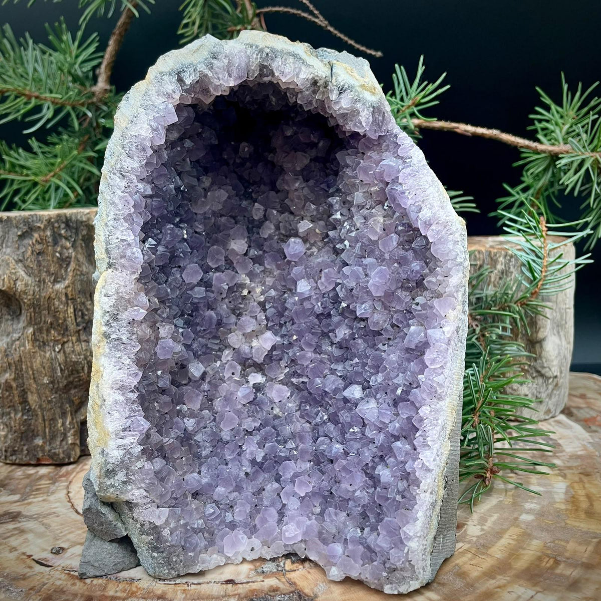 Natural Amethyst mineral specimen featuring purple quartz crystal formations and a freestanding cut base.