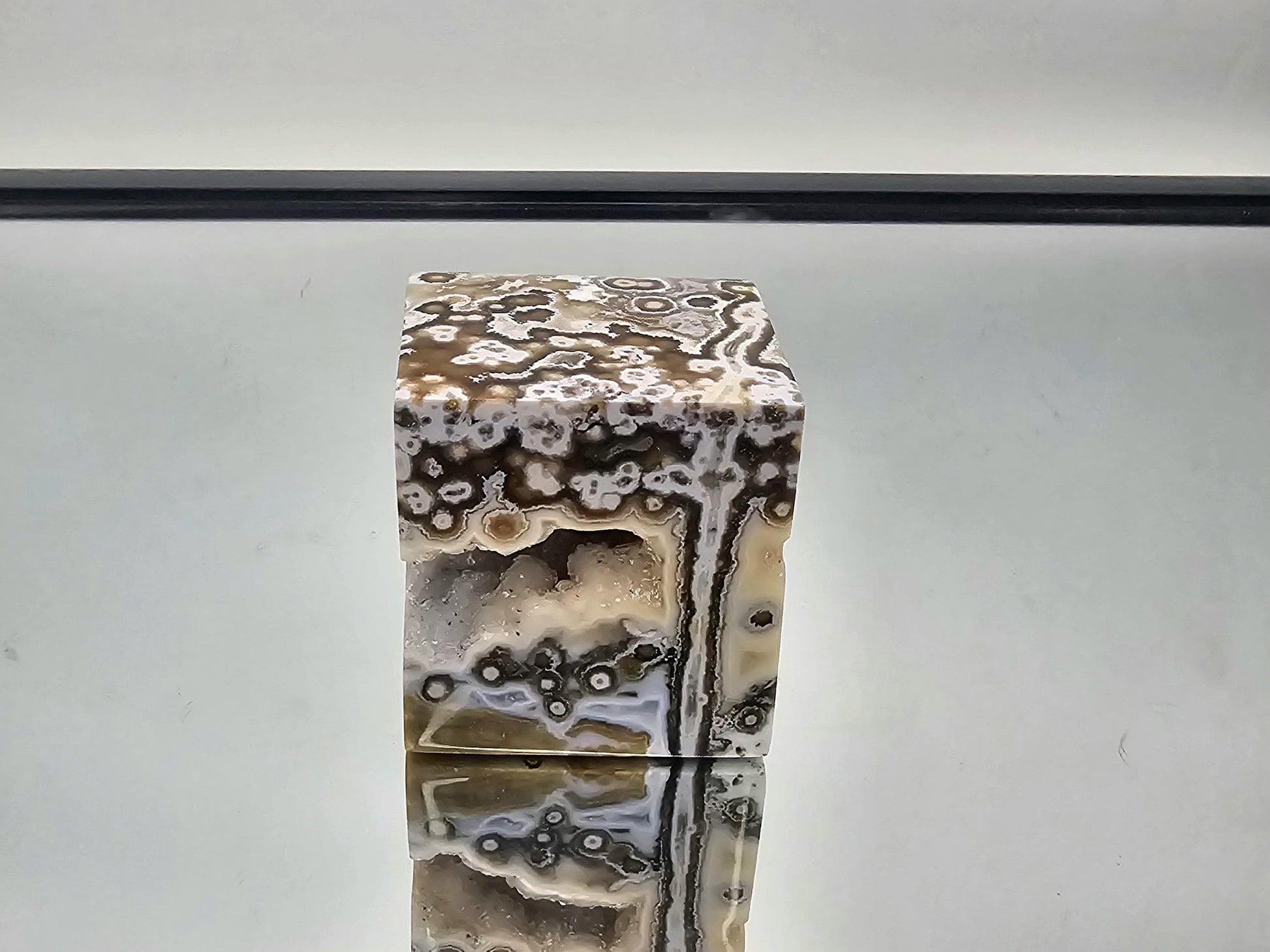 Close-up of the Ocean Jasper crystal cube's hollow, with detailed natural patterns.