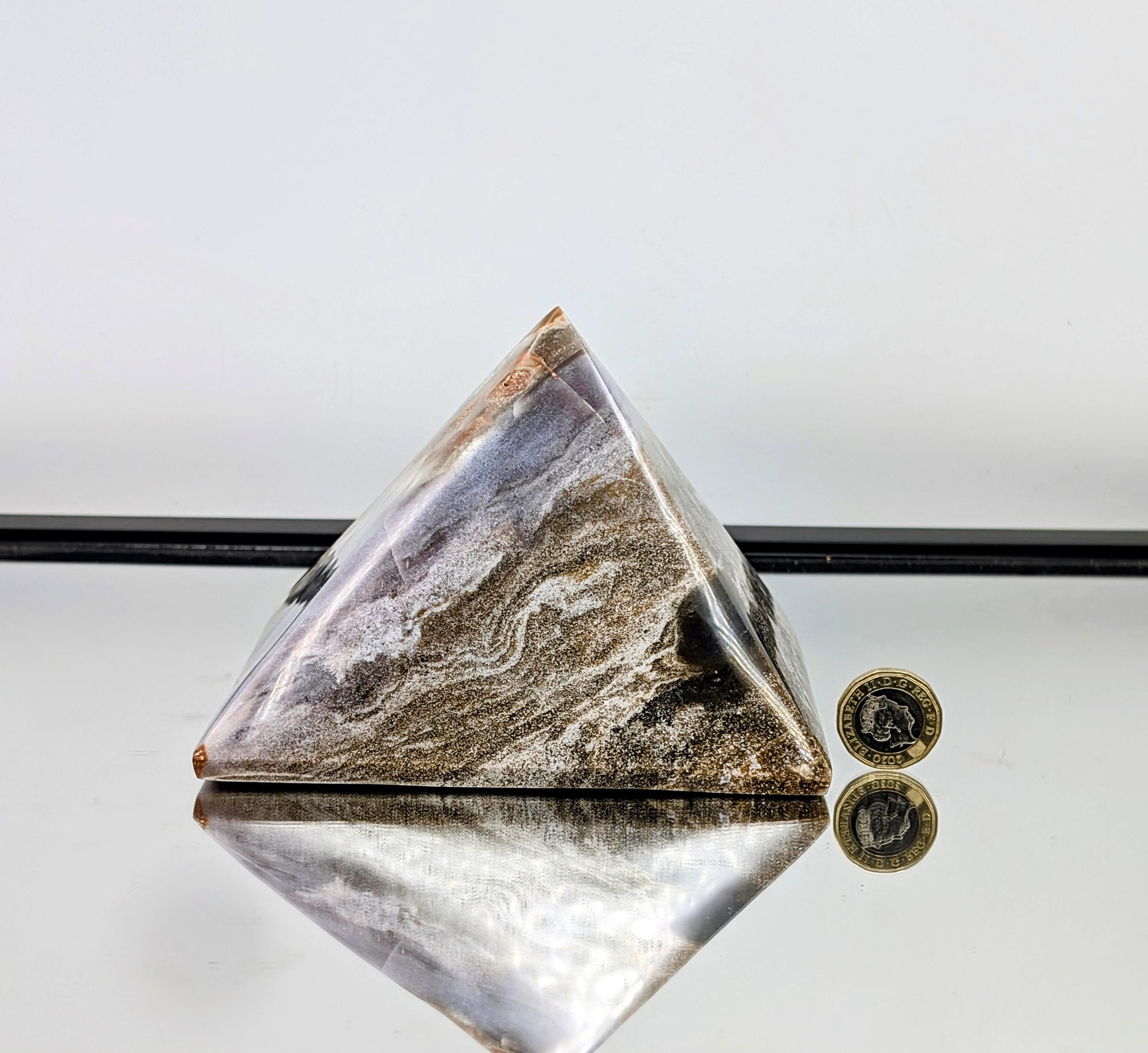 Features bold natural banding and swirling orb formations.