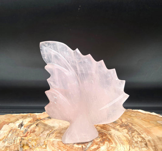 Front view of a polished pink Rose Quartz crystal leaf sculpture.