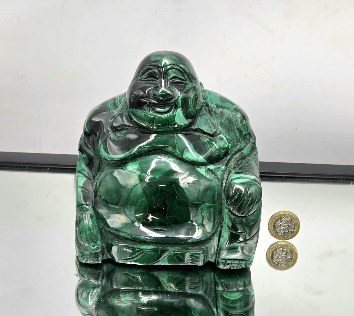 Polished Malachite Buddha sculpture featuring intricate natural patterns and smooth finish, symbolizing peace and transformation.