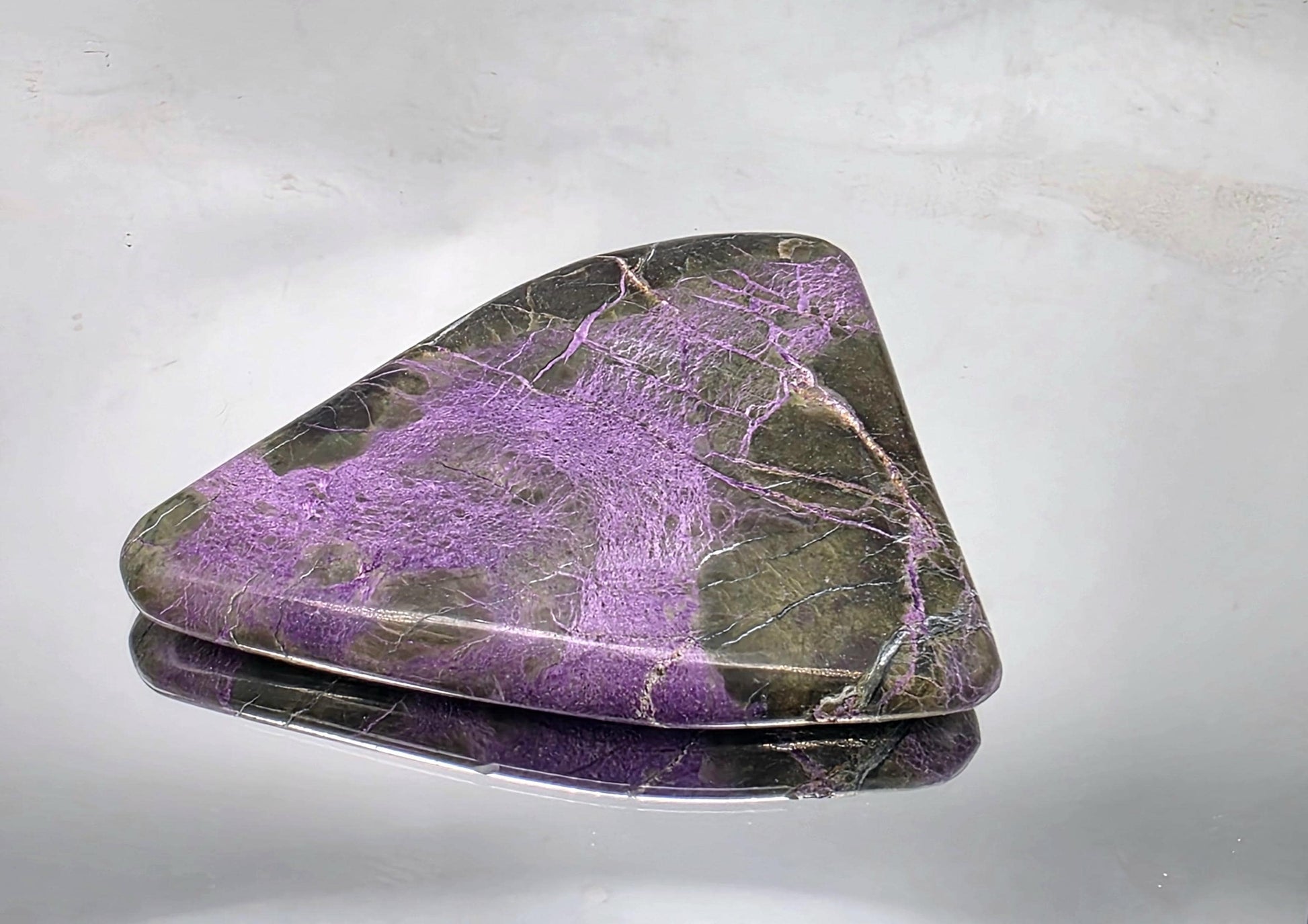 Handheld crystal with a polished surface, showing vivid colors.