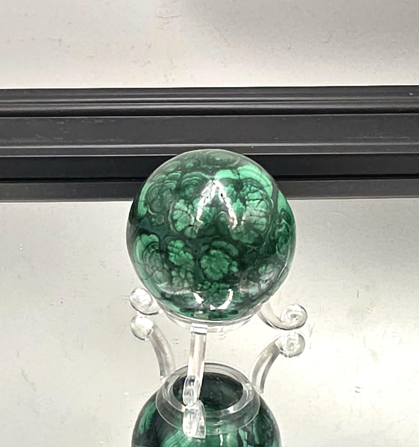 Premium green malachite sphere with floral detail.