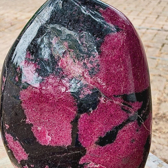 Close-up video showcase of the polished rhodonite freeform crystal.