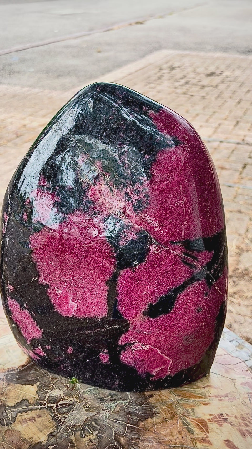 Close-up video showcase of the polished rhodonite freeform crystal.