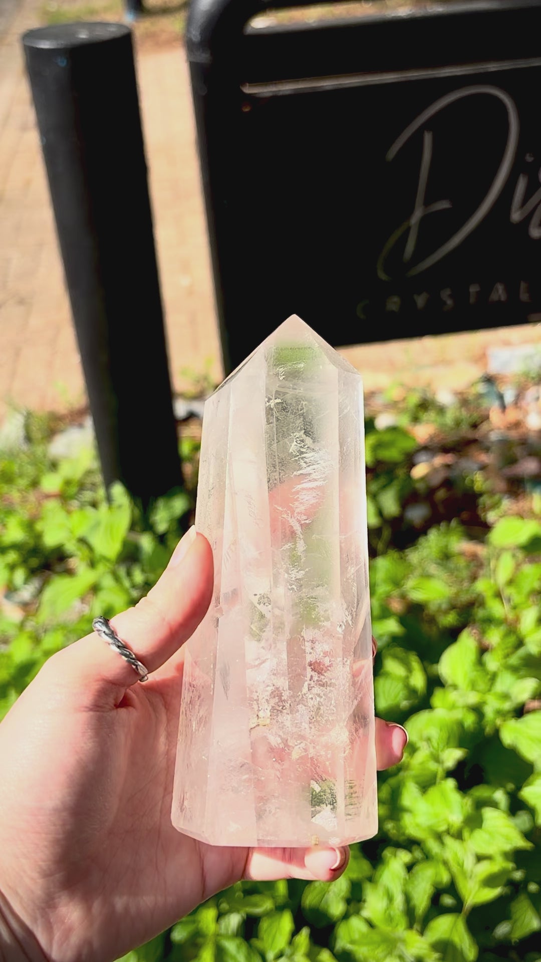 Large clear quartz polished tower with natural veiling, surface markings and decorative form.