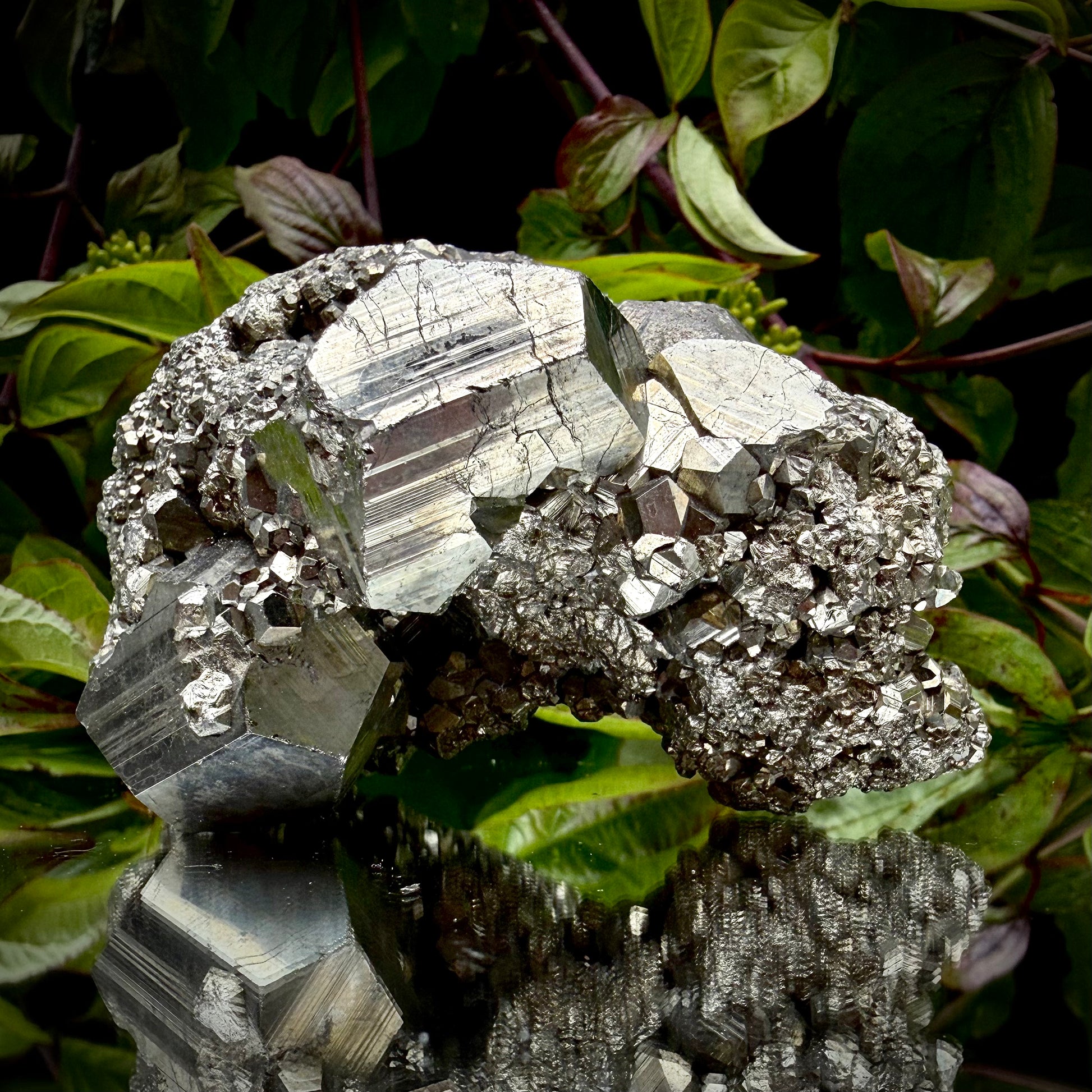 Close-up of multi-faceted geometric pyritohedral crystal formations on a raw Pyrite specimen.