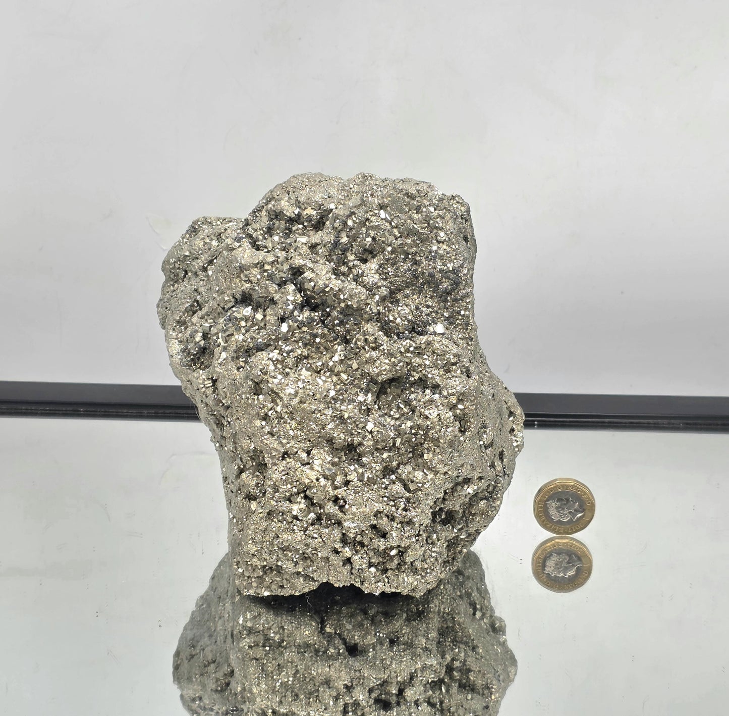 large Pyrite crystal cluster displayed on neutral background.