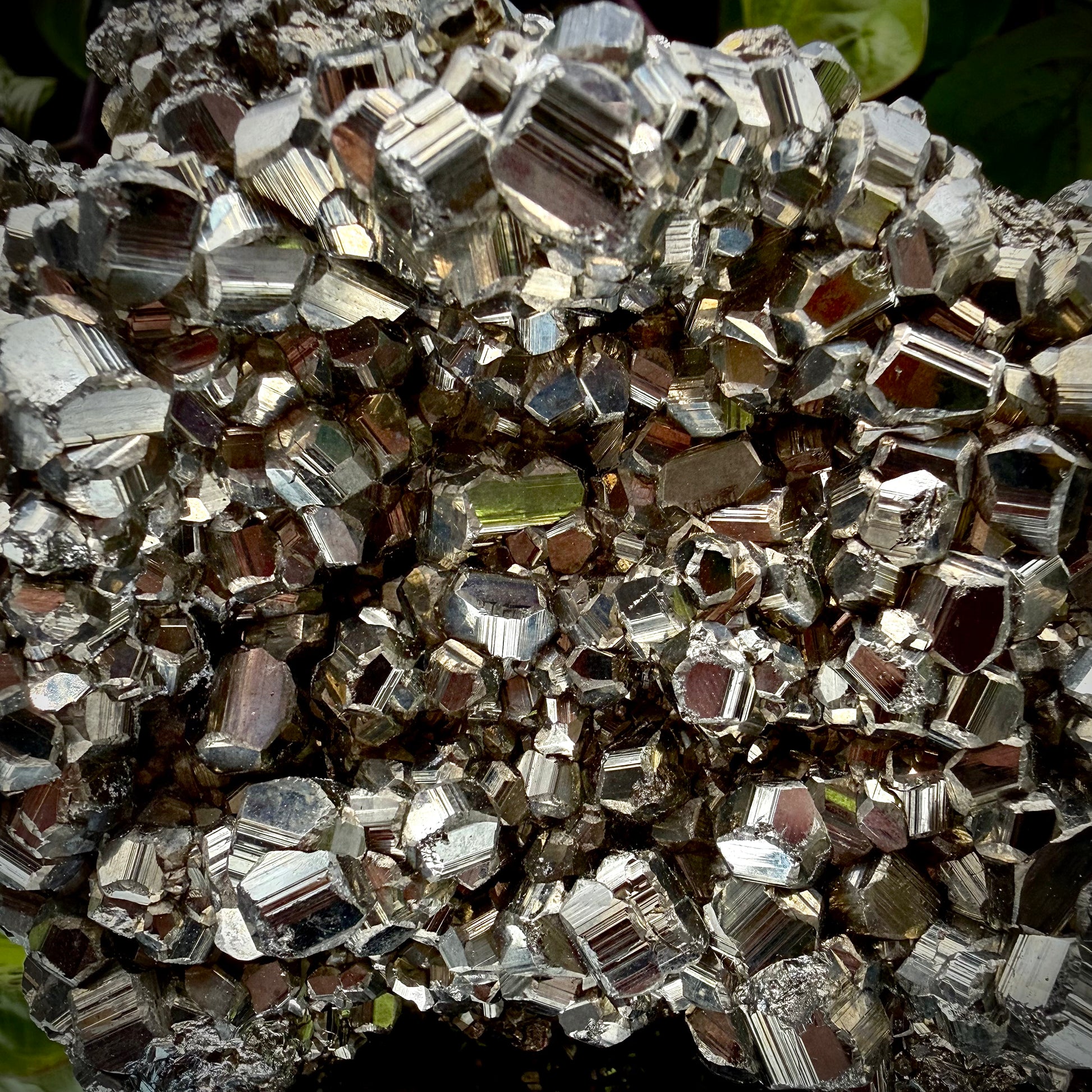 Close-up of multi-faceted geometric pyritohedral crystal formations on a raw Pyrite specimen.