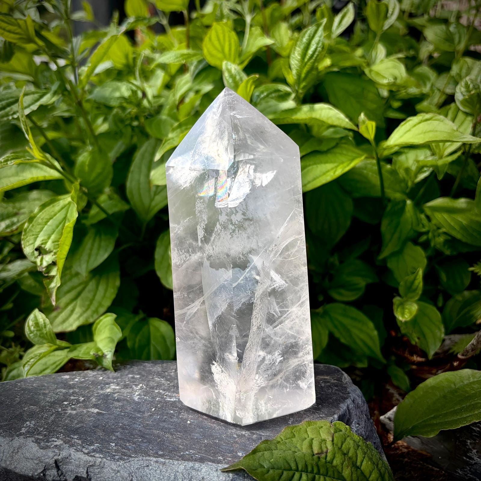 Quartz crystal tower with a natural rainbow inclusion and polished surface for decorative display.