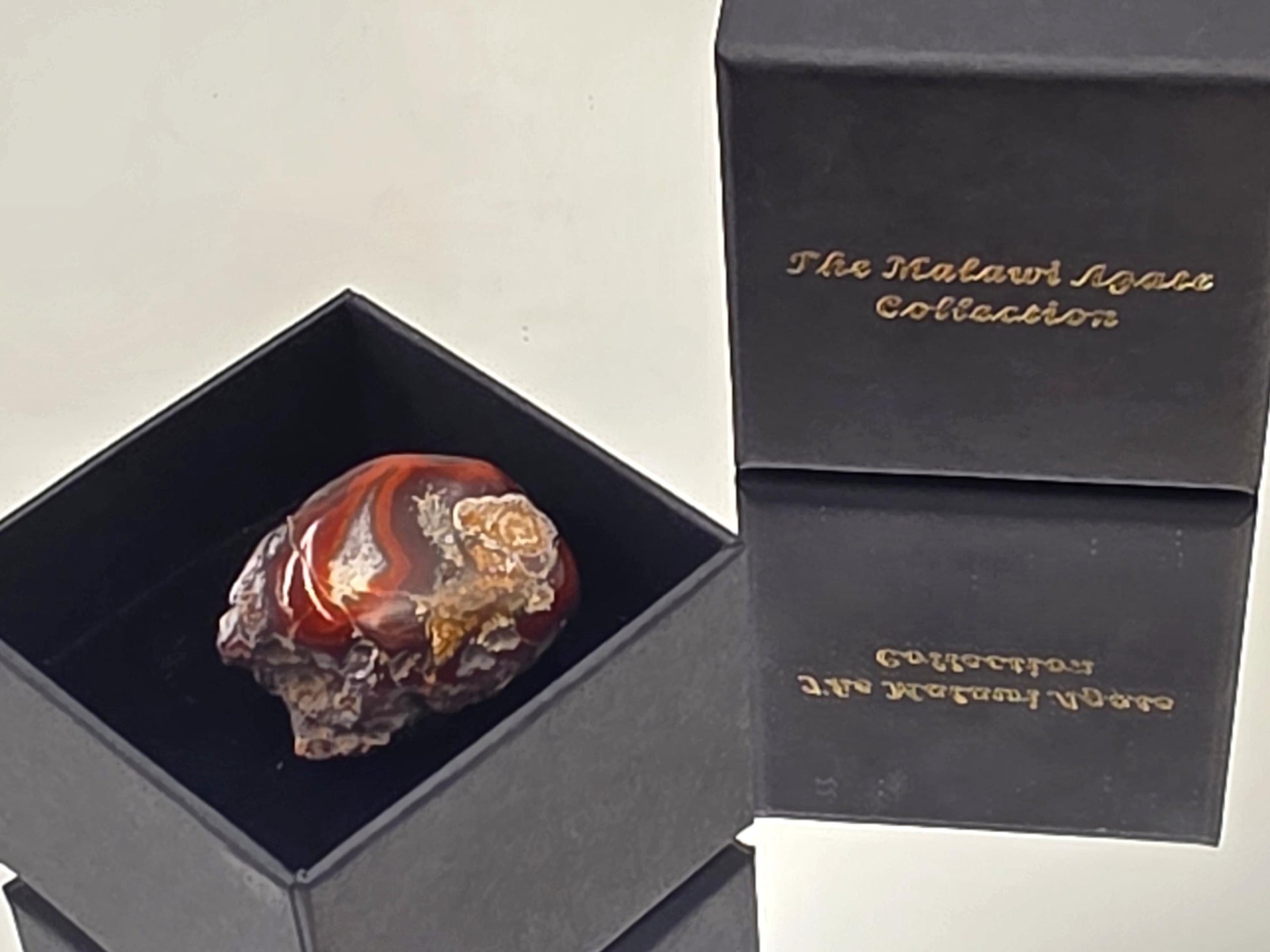 A collector’s Malawi Agate featuring rich colors and intricate patterns in a smooth finish.