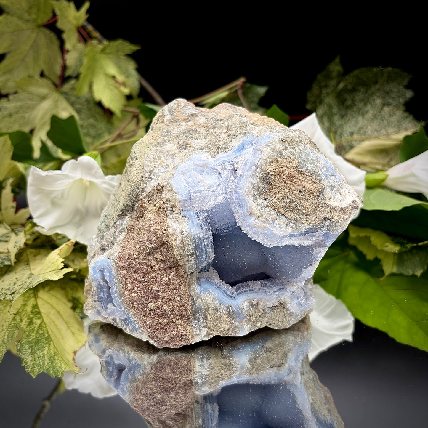 Natural Blue Lace Agate geode specimen with a prominent hollow cavity showing off light blue crystalline bands.
