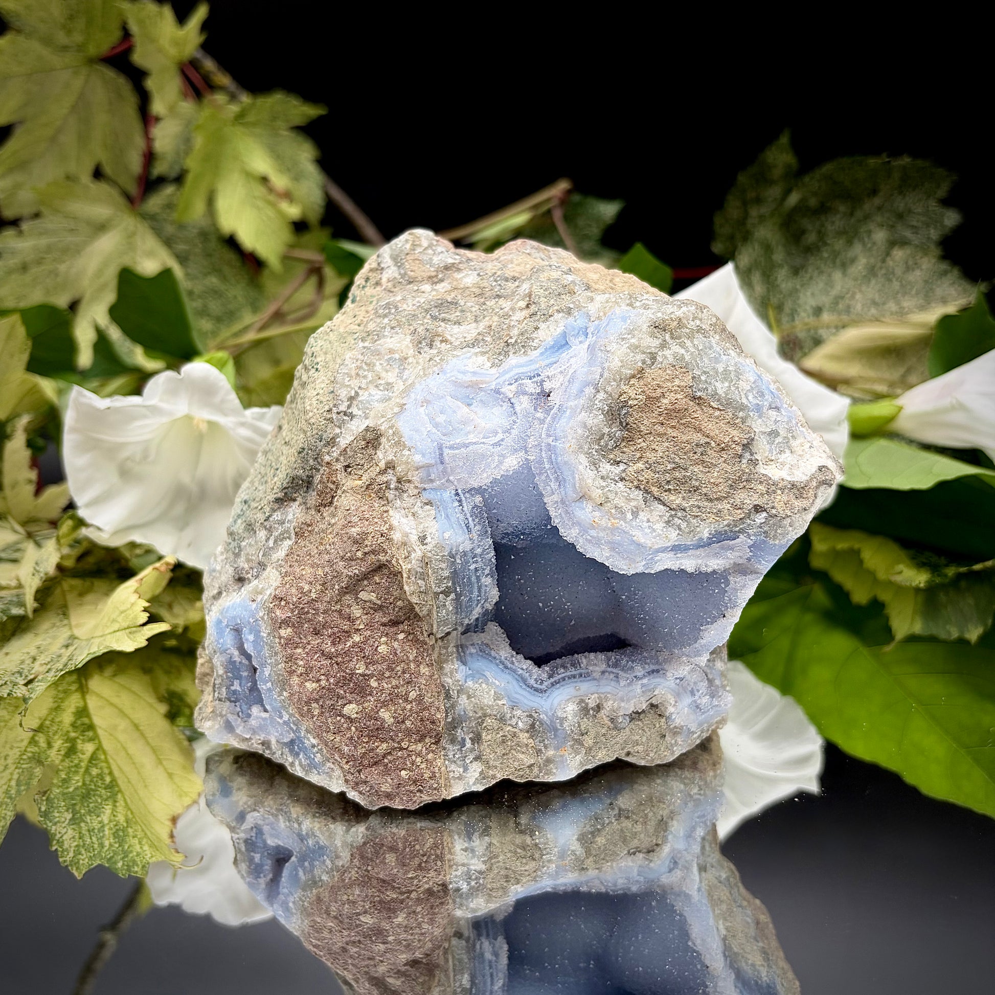 Natural Blue Lace Agate geode specimen with a prominent hollow cavity showing off light blue crystalline bands.