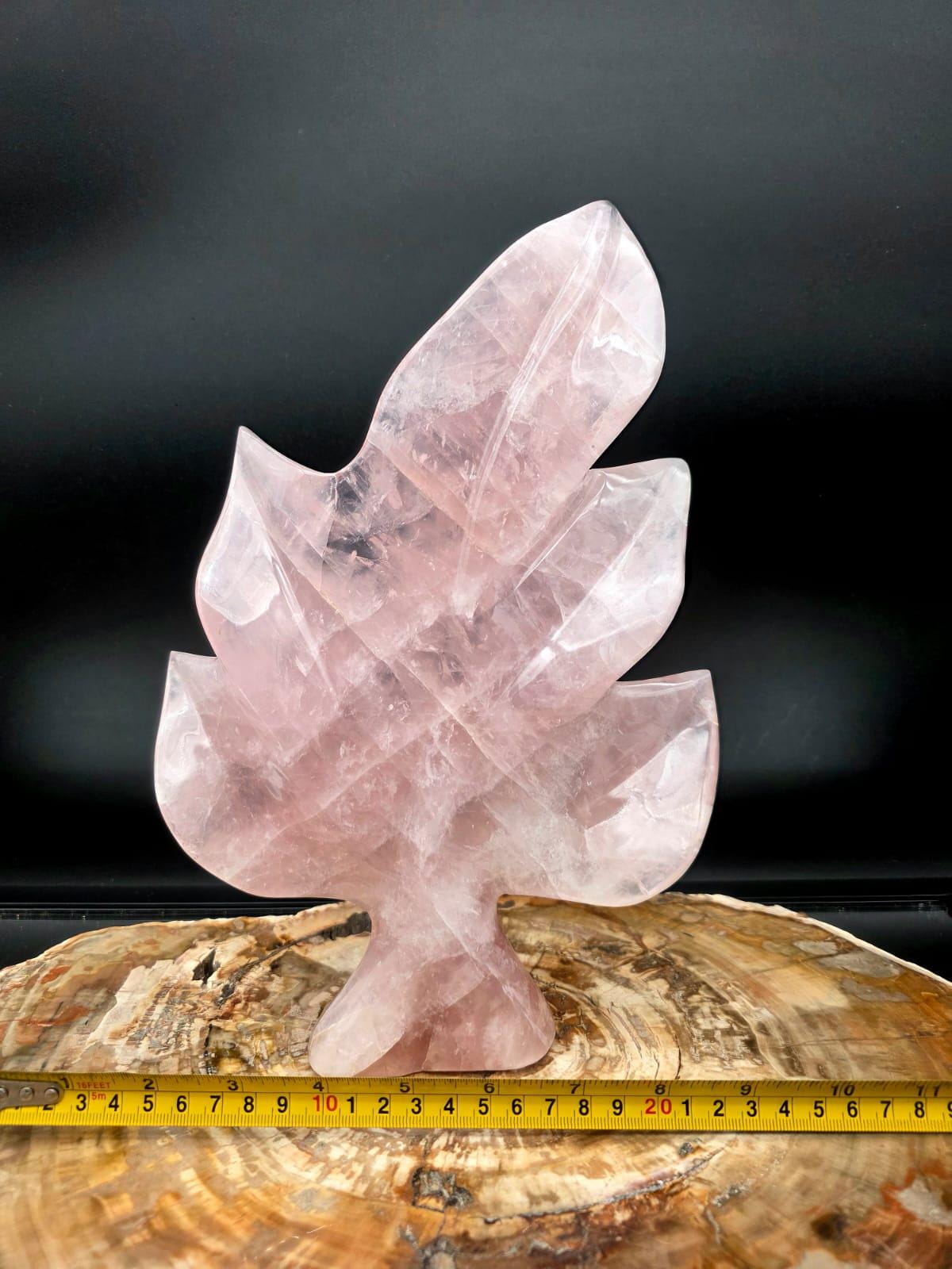 Angled view of a polished Rose Quartz leaf sculpture showcasing soft blush tones.