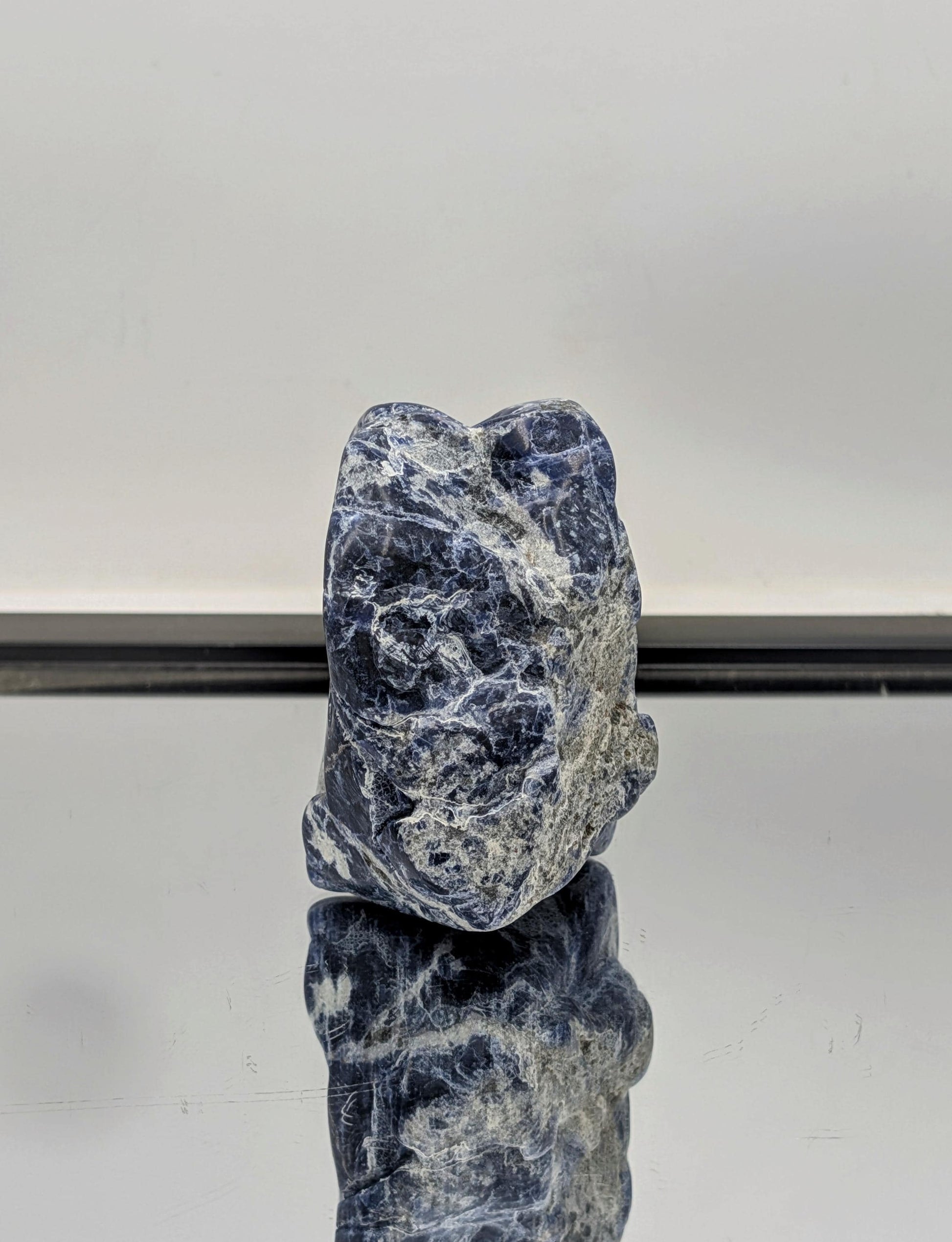 Partially polished Sodalite freeform crystal with raw, rough edges.