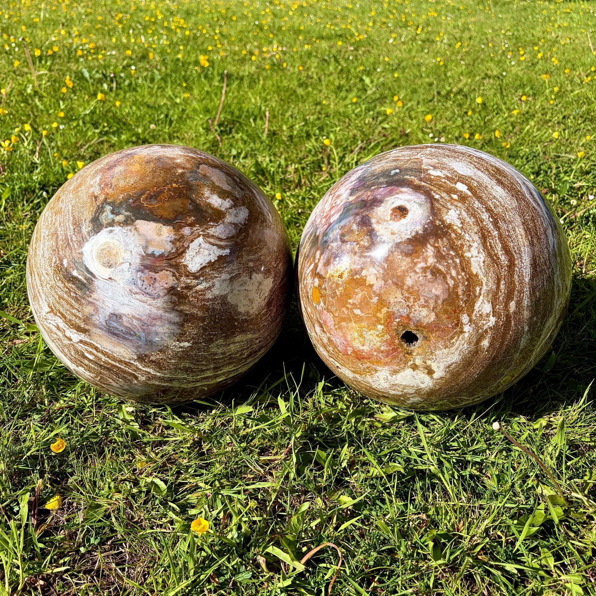 Side-by-side view of two XL Ocean Jasper spheres showing their massive scale and polished finish.