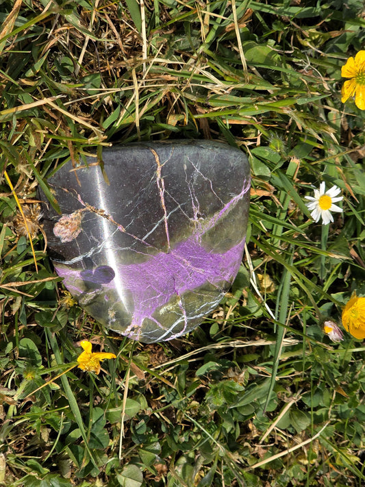 Atlantisite specimen featuring vibrant green and purple tones.