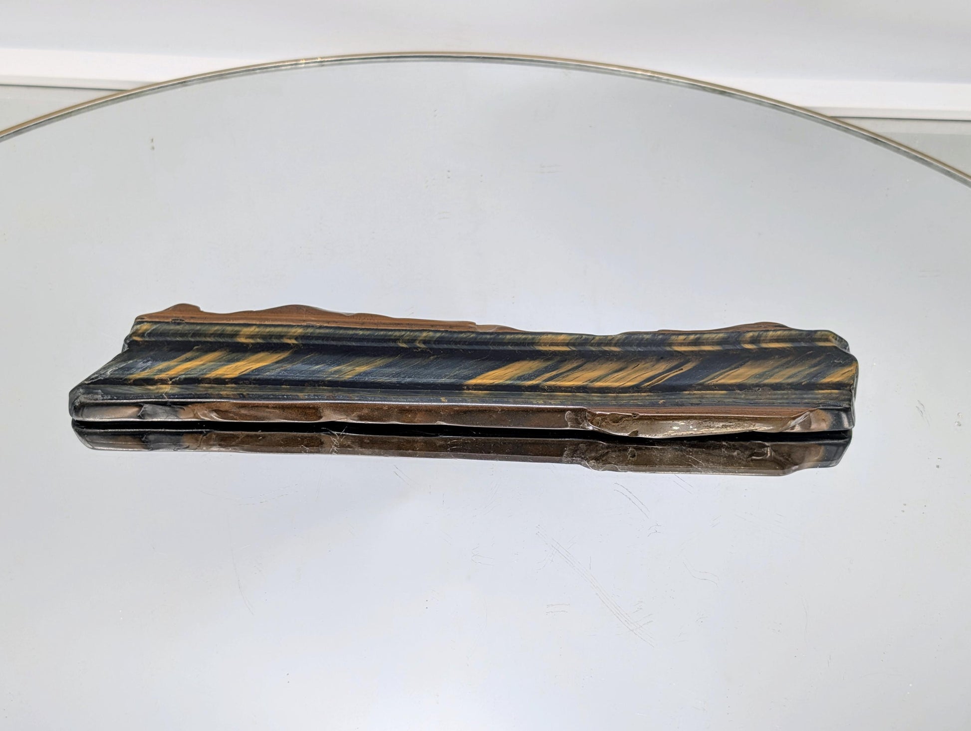 Large Tiger’s Eye slice displayed on a stand