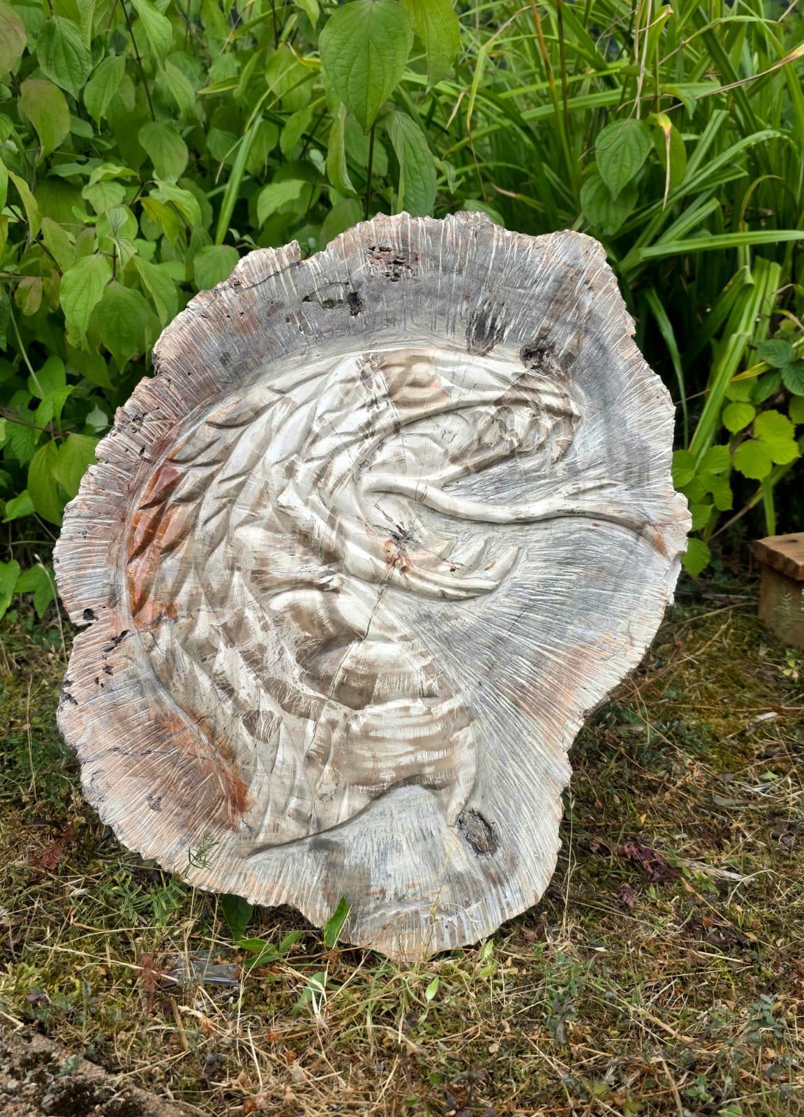 large cobra carved into fossil wood slice