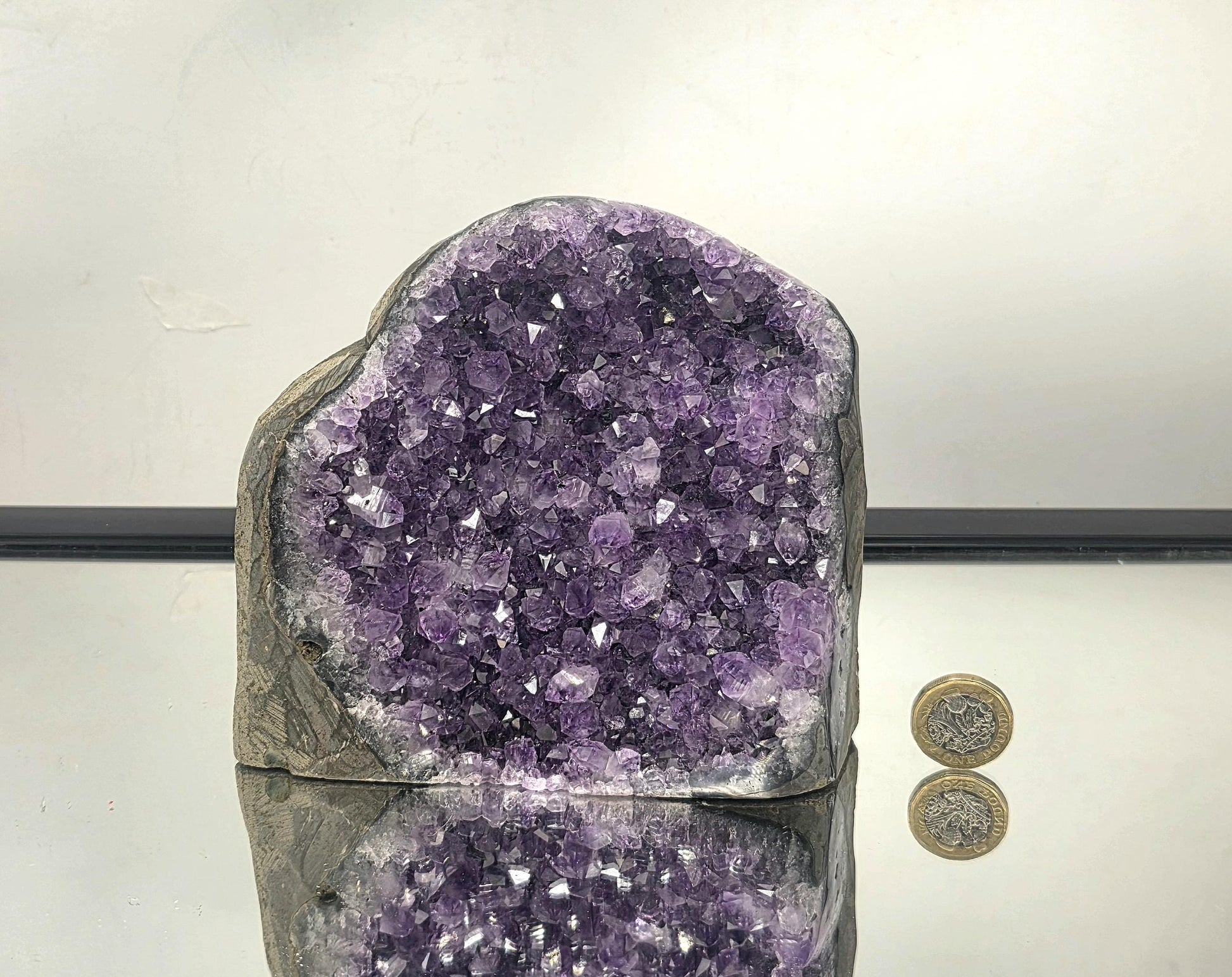 Side view of a large natural amethyst geode from Uruguay highlighting crystal depth and curved geode shape.