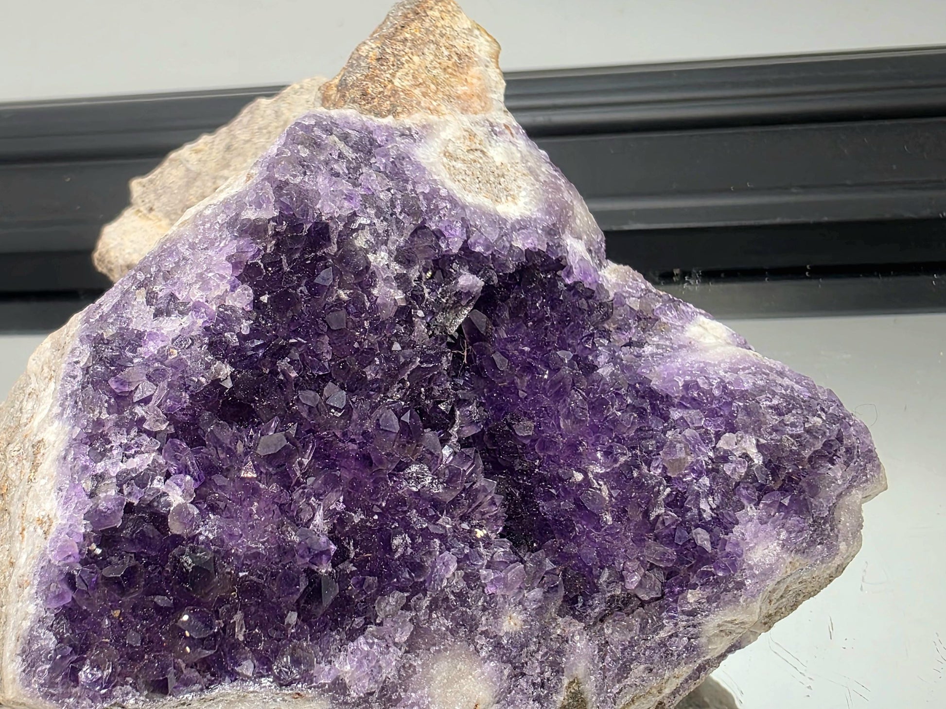 Dark violet Mapatizya amethyst cluster for display.