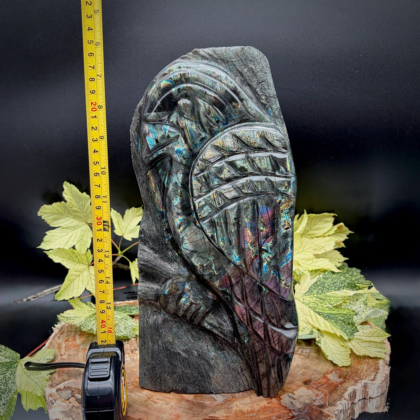 Side profile of a large polished Labradorite parrot carving displaying vibrant blue, gold and purple flash.